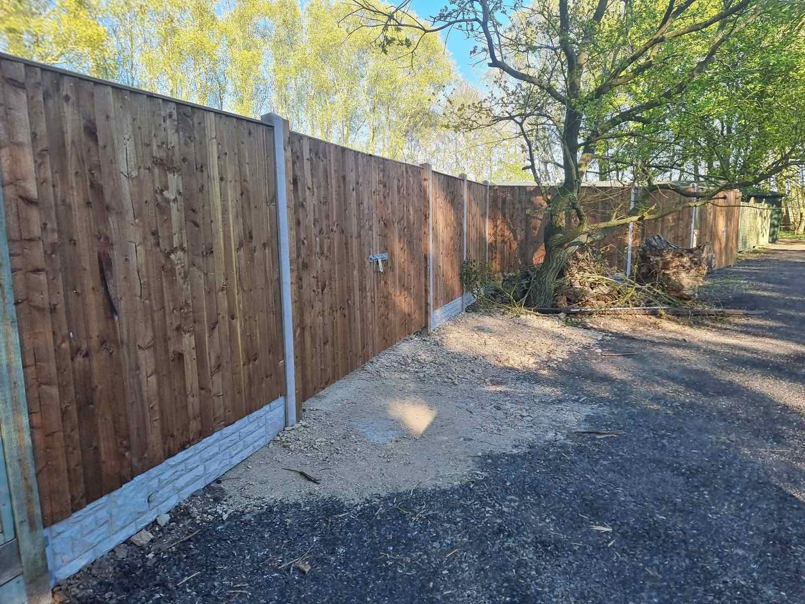 New close-board fence panels with concrete gravel boards along a boundary