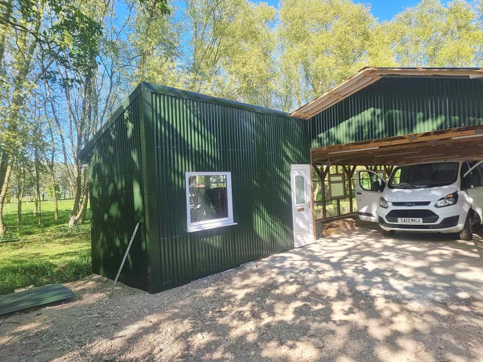 Corrugated steel outbuilding with a new door and window alongside an open timber carport