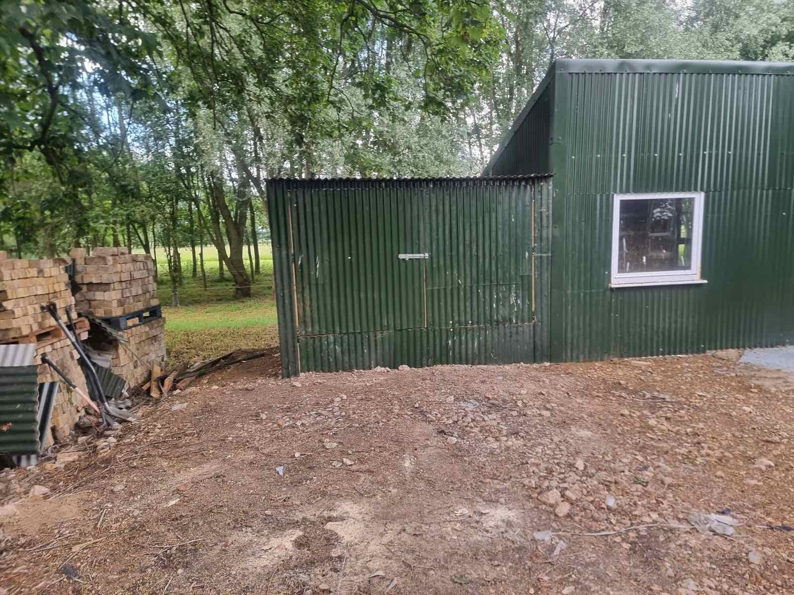 Green corrugated steel outbuilding with a new window fitted