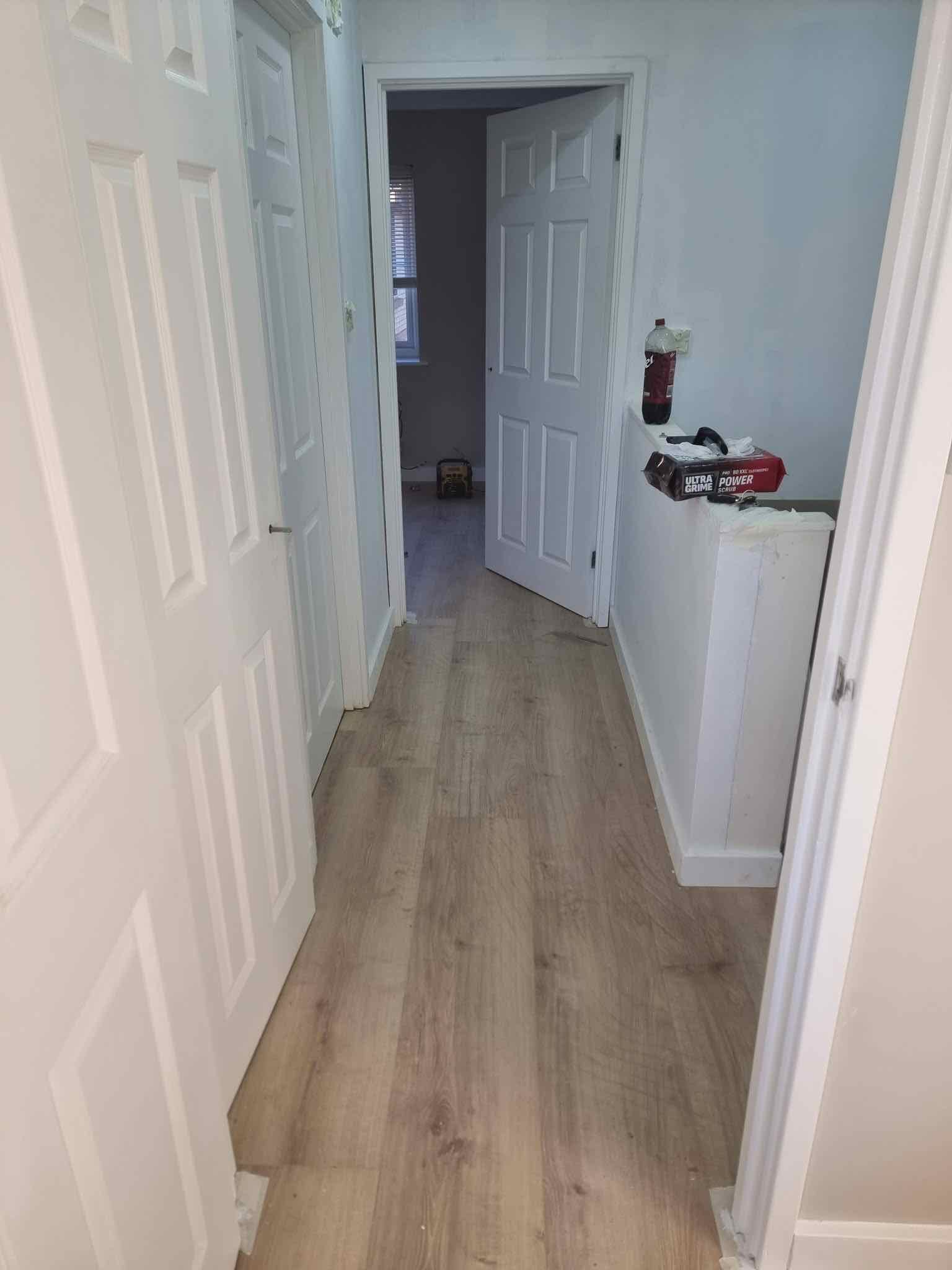 Freshly fitted wood-effect flooring running through a hallway